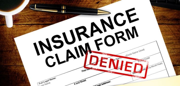 Close-up of a denied insurance claim form, symbolizing the risks of inadequate cyber insurance coverage