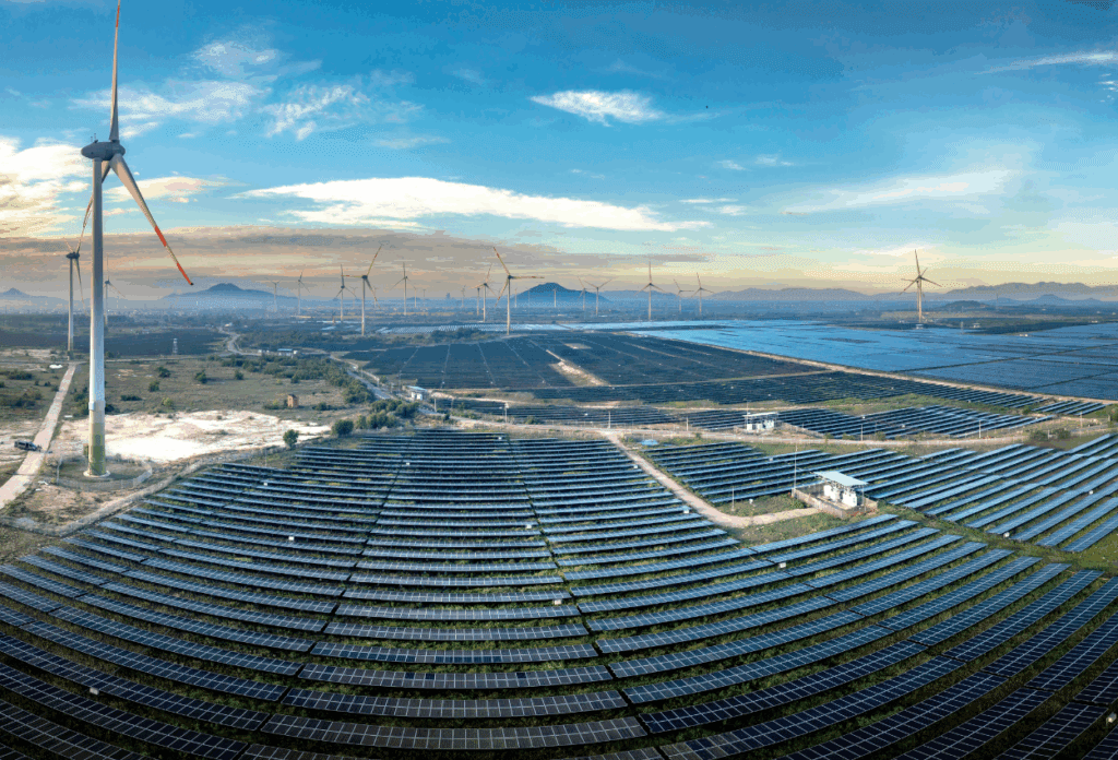 Aerial view of large scale solar panels and wind turbines, representing modern energy infrastructure in the energy sector and the growing risk of IT failures impacting critical operations.