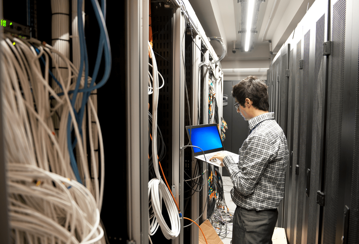 IT professional working in a data center environment, managing servers and network infrastructure as part of a managed IT services provider supporting secure and reliable business operations.