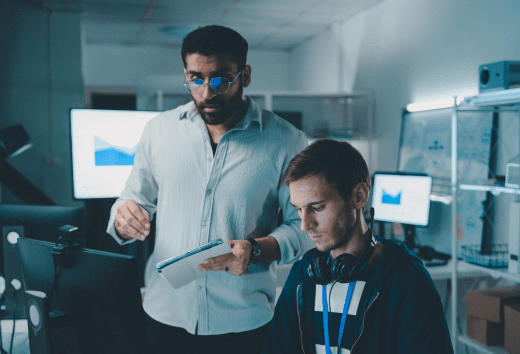 IT team collaborating at computer workstations while reviewing performance data and security metrics with a managed service provider.