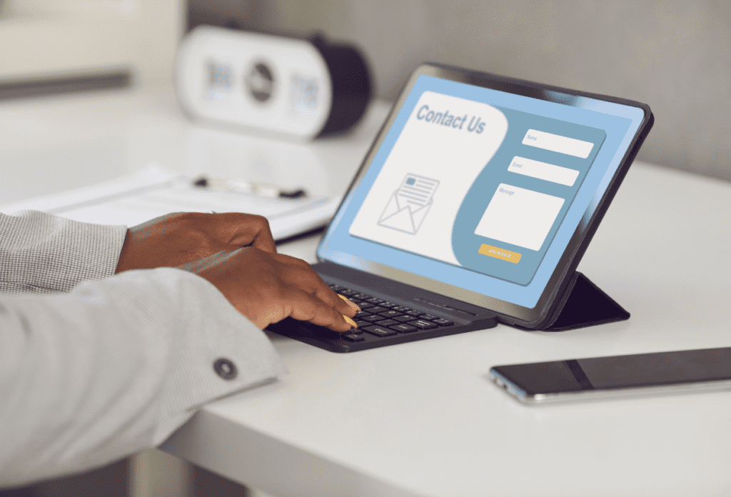 Person filling out a website contact form on a tablet, highlighting potential contact form security risks businesses should be aware of.