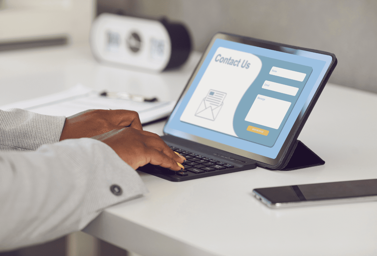 Person filling out a website contact form on a tablet, highlighting potential contact form security risks businesses should be aware of.