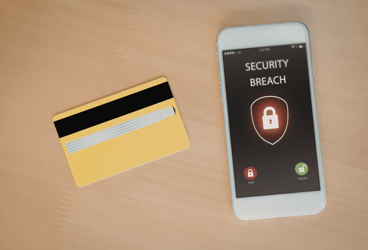 Credit card and smartphone displaying security breach warning related to credit union cybersecurity